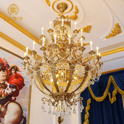 Ornate French brass crystal chandelier in an opulent room with gold trim and red artwork.