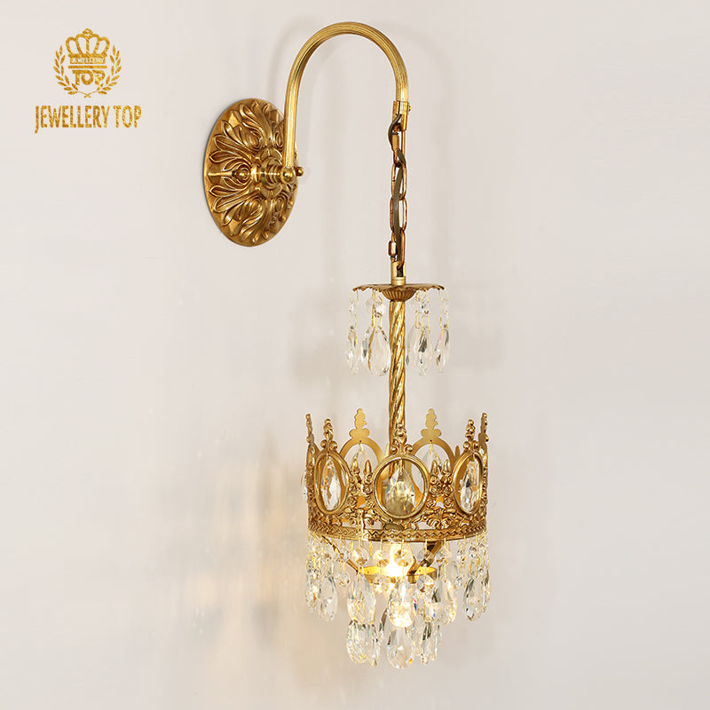 JEWELLERY TOP branded golden brass wall lamp with crystal pendants, installed on a light-colored wall.