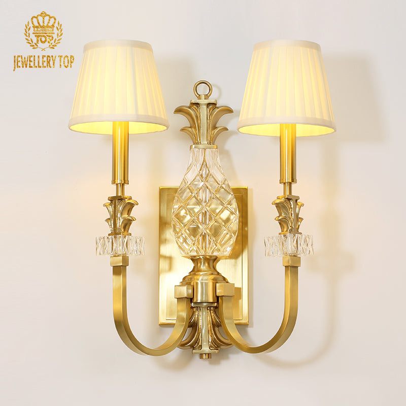 JEWELLERY TOP branded product shot of the golden hotel wall lamp with a crystal pineapple centerpiece.