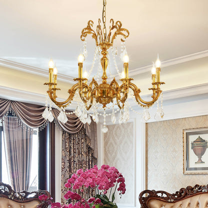 The brass chandelier installed in an elegant room with pink orchids, curtains, and artwork.