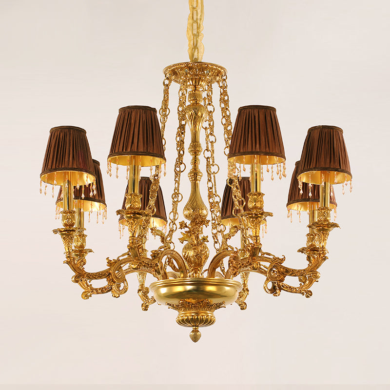 Golden rococo brass chandelier with brown pleated lampshades and crystal drops, isolated on white.
