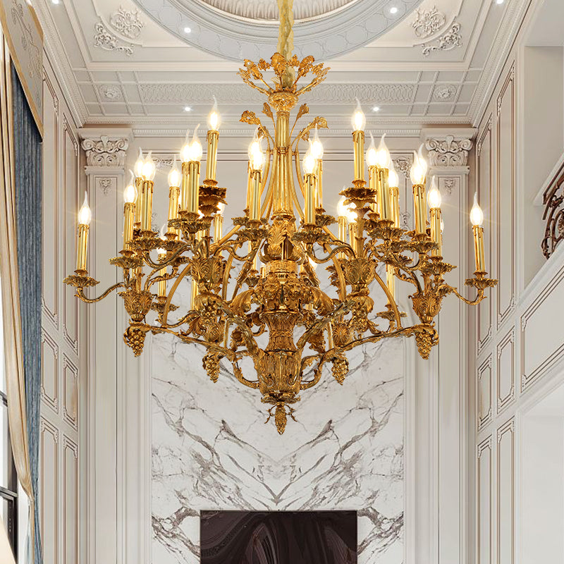 A grand Baroque-style brass chandelier installed in an opulent interior with marble walls and ornate ceiling.