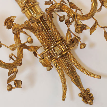 Extreme close-up of the sconce’s central column, featuring delicate rose relief and woven texture.