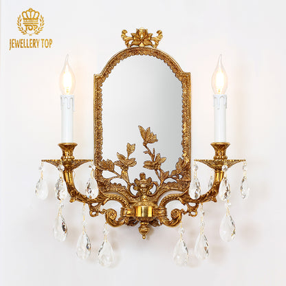 JEWELLERY TOP brand product close-up of the golden brass wall light with mirror and two candle bulbs.