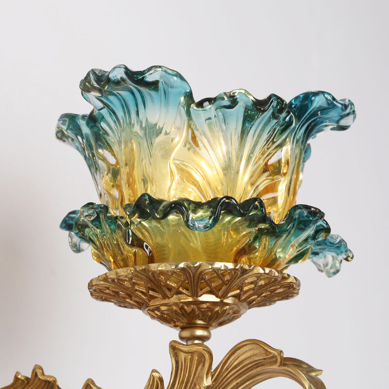 Detailed macro shot of the hand-blown peony-shaped glass shade with its teal-to-gold gradient and fluted edges.