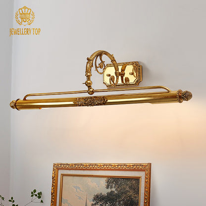 The vintage brass wall lamp installed above a bathroom mirror, reflecting in the glass alongside decorative bottles.