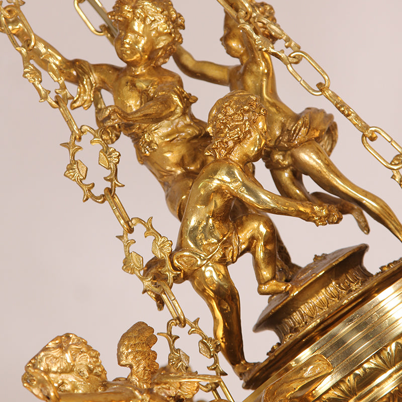 Macro detail of interconnected cherub sculptures and ornate brass scrollwork on the chandelier.