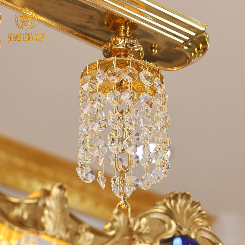 Macro close-up of the deep blue oval crystal embellishments and the detailed brass foliate carvings along the frame.