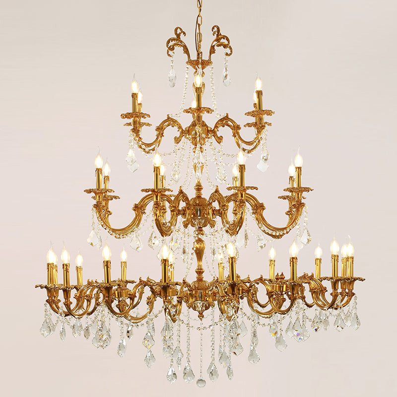 A luxury brass chandelier with multiple candle-style lights and sparkling crystal decorations.