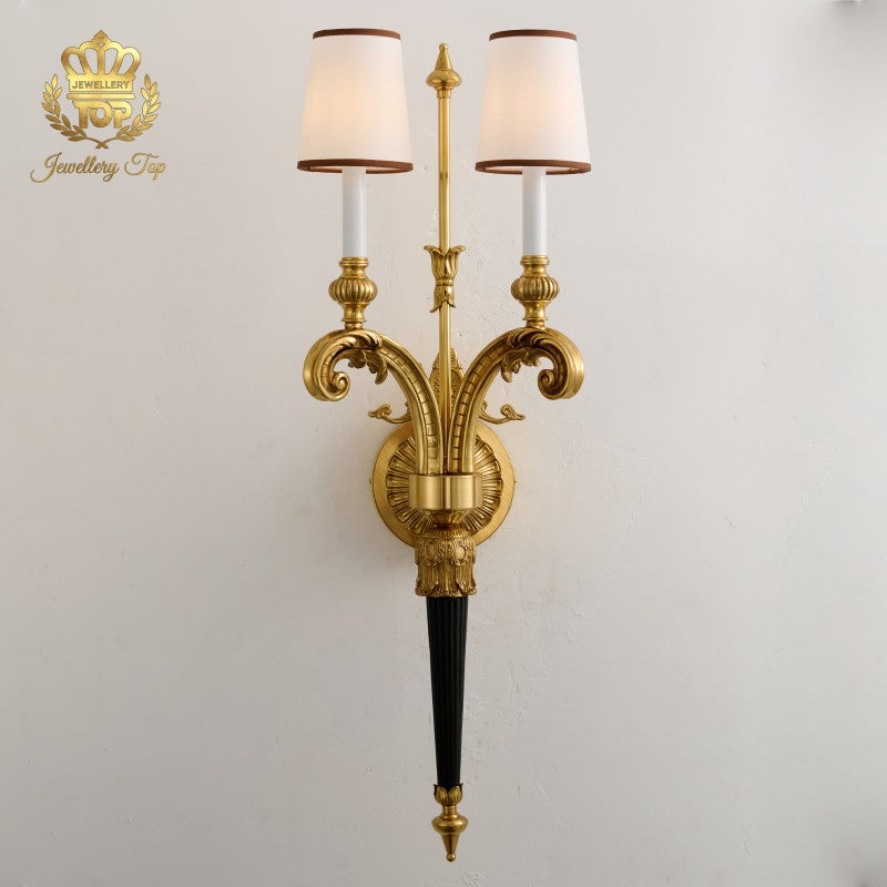 View the elegant symmetry of The Athena Victorian wall sconce by Jewellery Top. Featuring solid brass, fabric shades, and a striking 35-inch height.