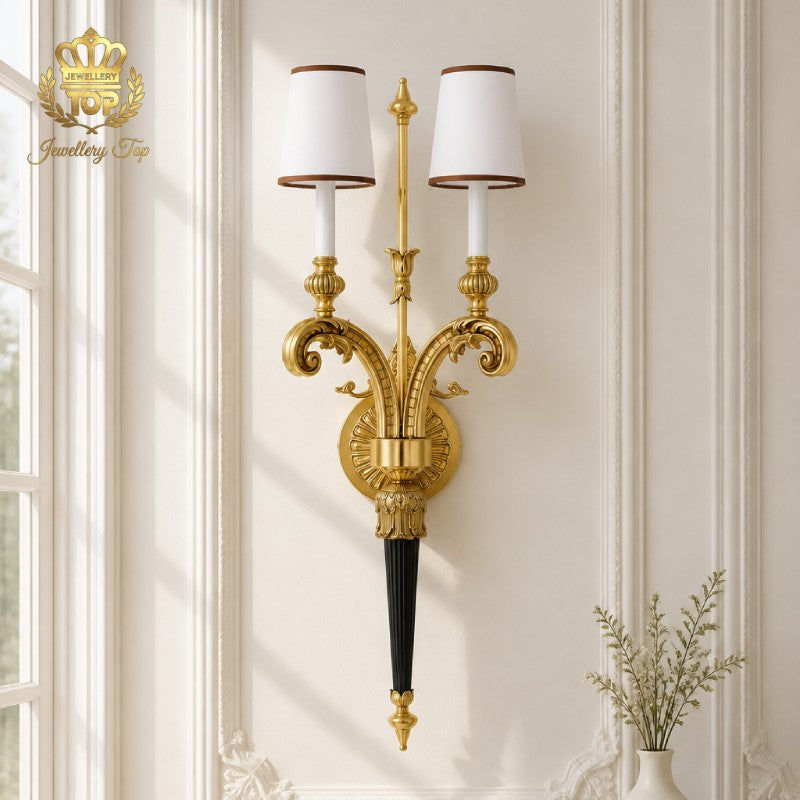 Brighten your classic interior with The Athena wall sconce by Jewellery Top. Solid brass and white fabric shades create timeless elegance in any room.